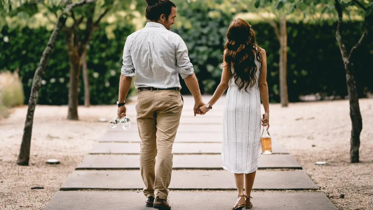 man and woman walking on a pathway holding hands - Maintaining strong relationships