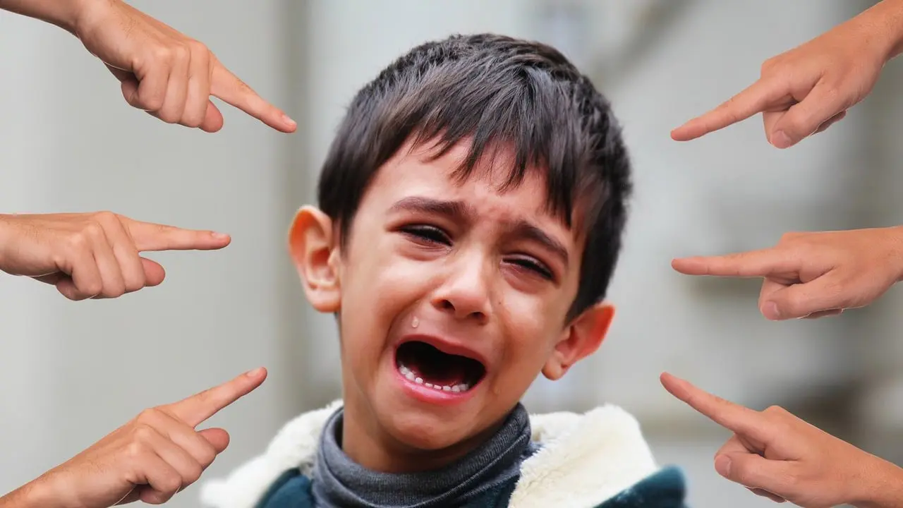A distressed young boy with six hands all pointing at him - Bullying at school