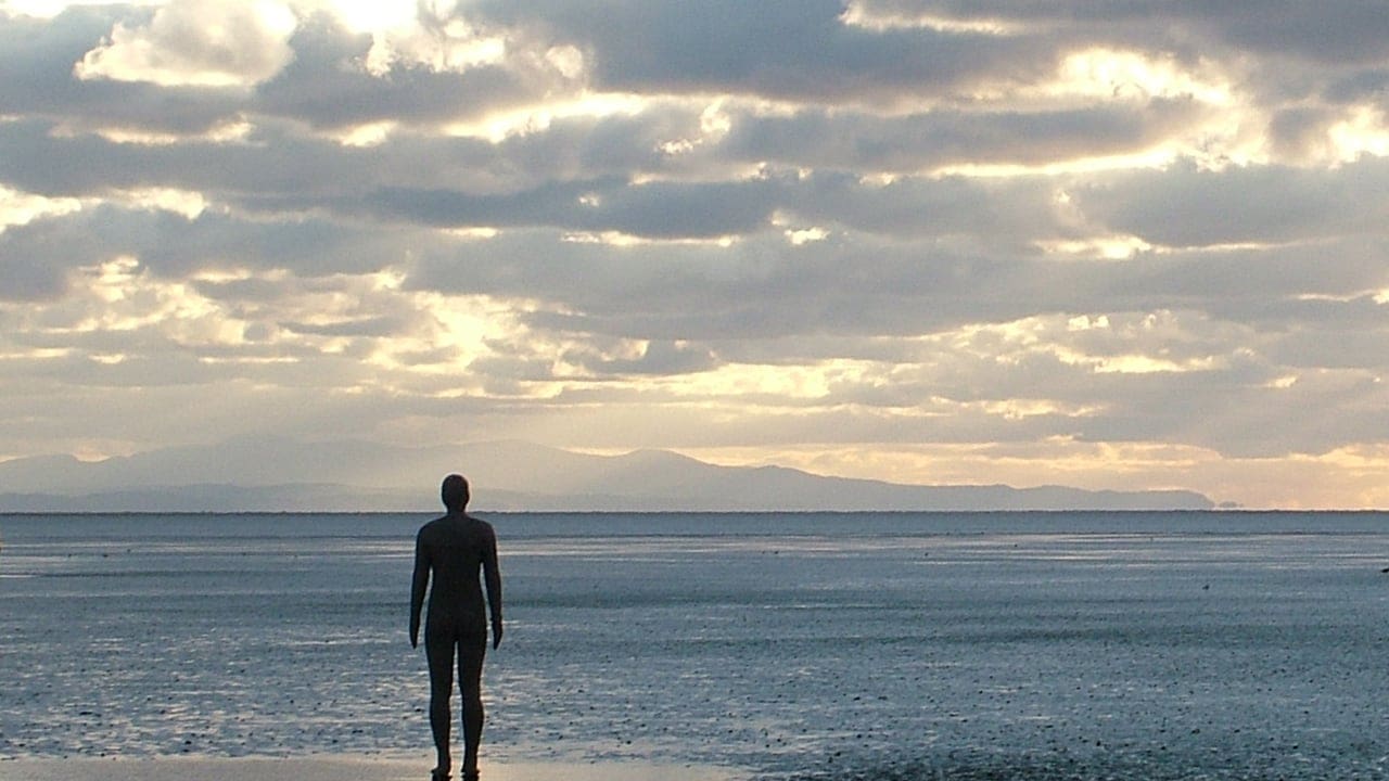 a single iron man standing alone - Crosby Beach, Another Place by Antony Gormley - social isolation and loneliness