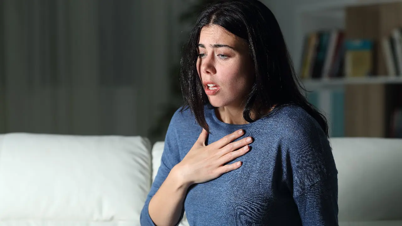 anxiety-symptoms An anxious woman clutching her chest - physical symptoms of anxiety