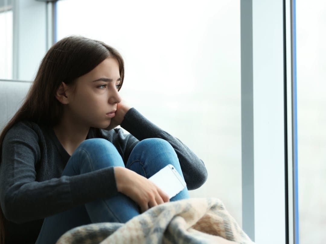 A child struggling with depression looking into space